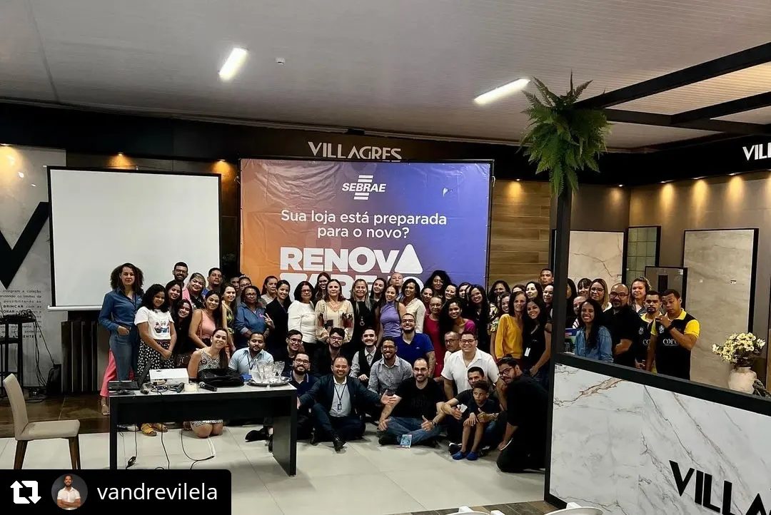 Plateia de empresários em evento do Renova Varejo, com o banner do programa ao fundo