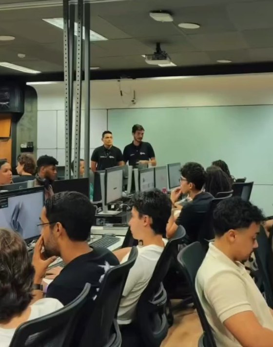 Matheus Ché e Eduardo Santos, de camisa preta, em frente à turma no laboratório de computação da UFBA